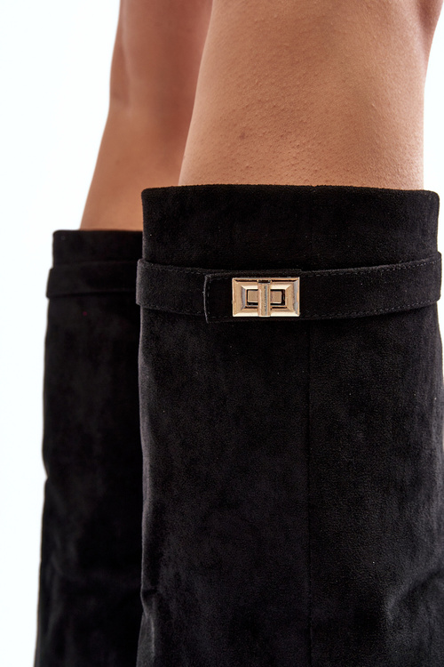 Ženské topánky na stĺpiku pred portrétom kolena čierneho